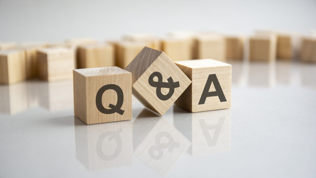 Q and A - an abbreviation of wooden blocks with letters on a gray background. Reflection of the Q and A caption on the mirrored surface of the table for a lawyer for motorcycle accident