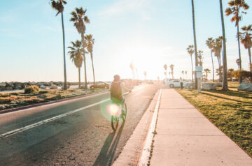Person bicycling into sunset in Long Beach, California.