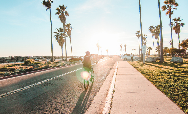 Person bicycling into sunset in Long Beach, California.